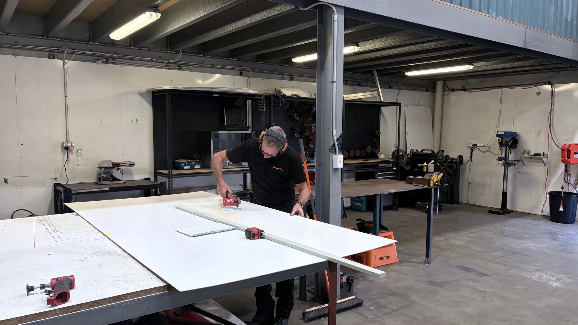 Apex tradesman measuring and cutting a cabinetry panel for a caravan interior fit-out