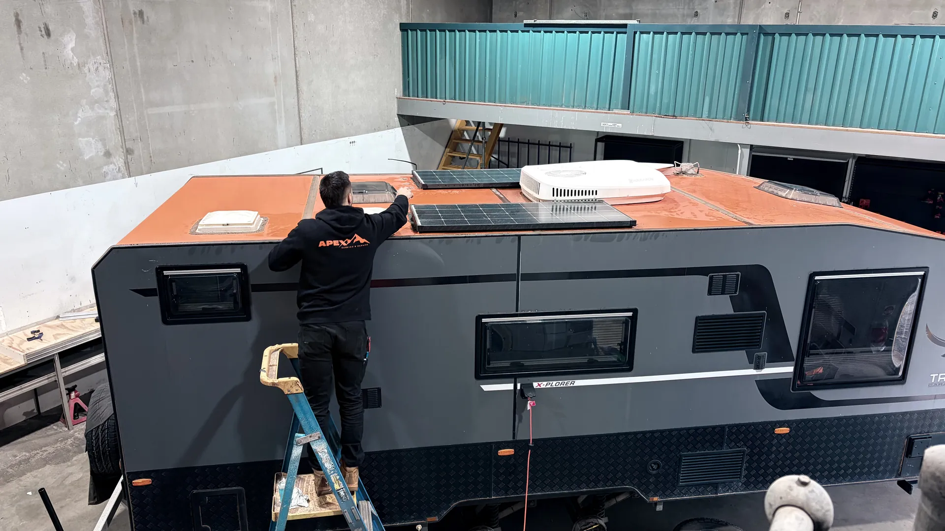 Apex technician fitting a solar panel to a caravan roof