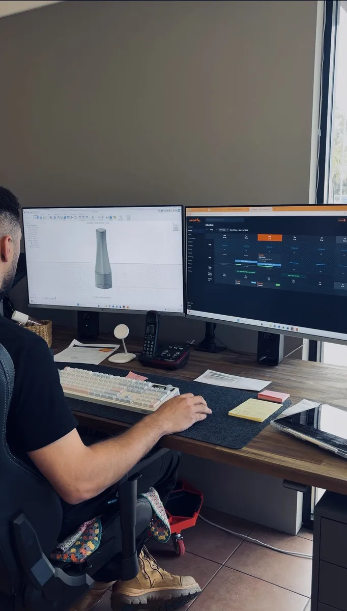 Mark at dual monitors with CAD design and booking schedule